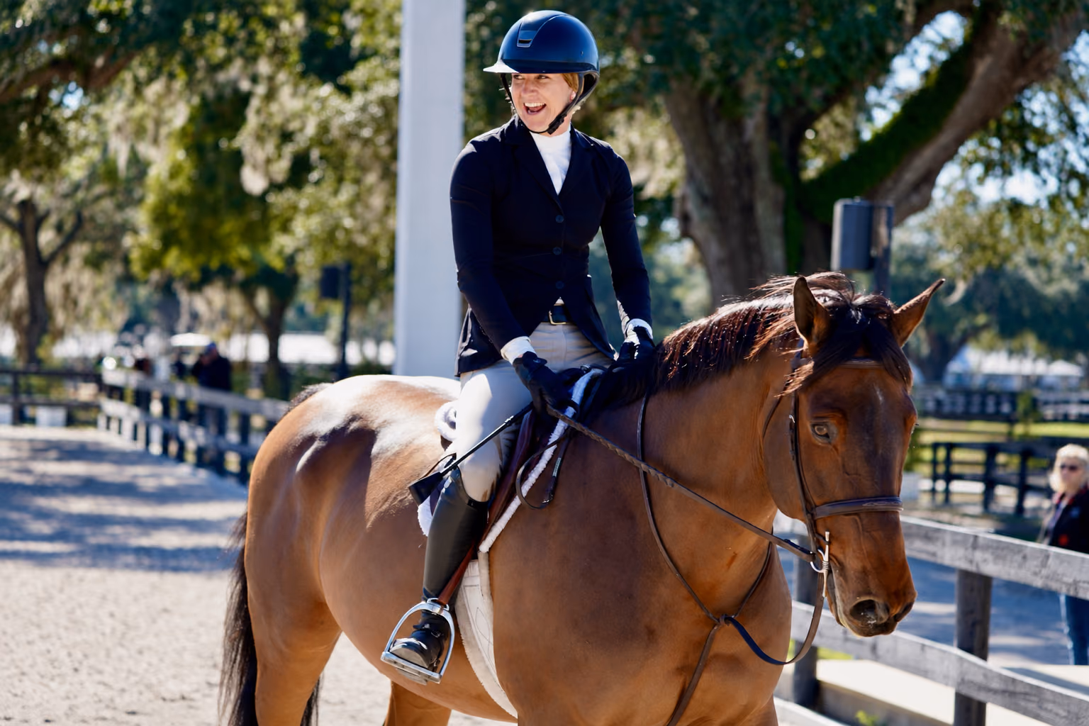 Alexa Harris smiling while mounted on a bay horse